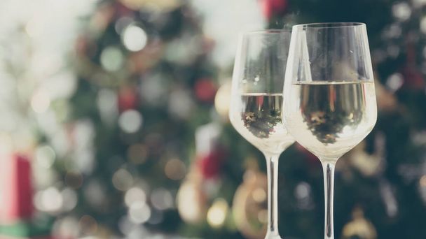 Різдвяна та новорічна вечірка з шампанським та розмитим орнаментом на фоні прикрашеного дерева
 - Фото, зображення
