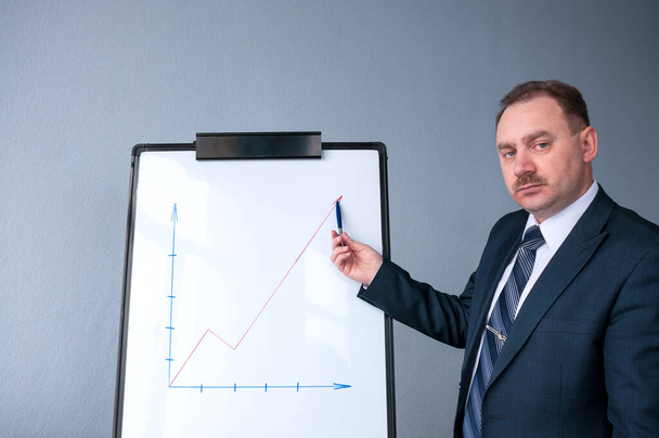 A man in a suit shows a growing profit - Foto, Imagem