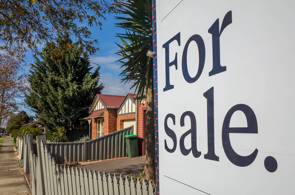 Close up of a real estate sign board with text  'for sale' , some suburban houses/Australian homes and pedestrian walkway as background. Concept of selling property and real estate market/investment. - Photo, Image