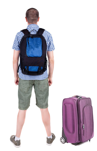 Back view of young man traveling with suitcase. - Fotó, kép