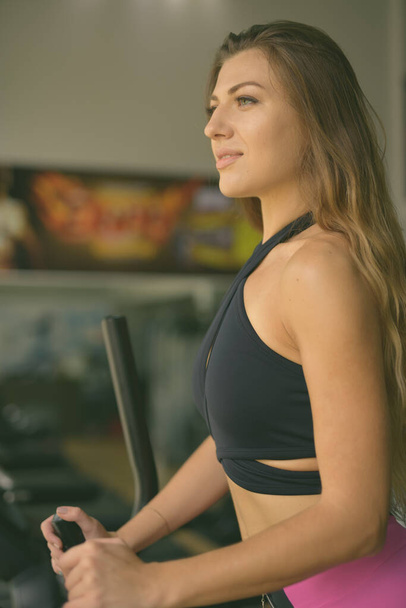 Portré fiatal gyönyörű nő edz az edzőteremben - Fotó, kép