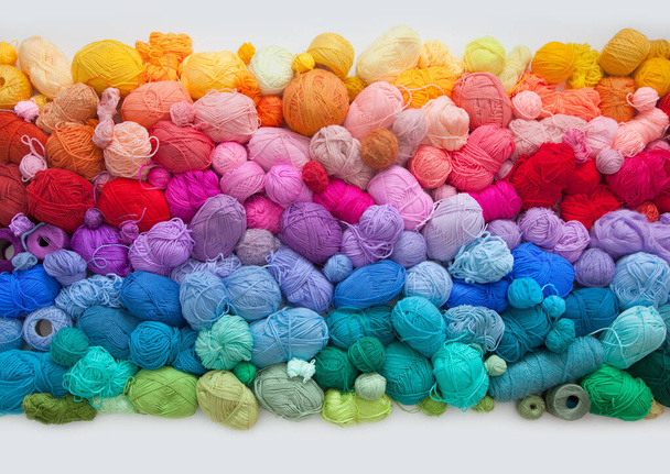 Many colorful balls of wool and cotton yarn for knitting. White background. Stretch and gradient. Rainbow layout. - Photo, image