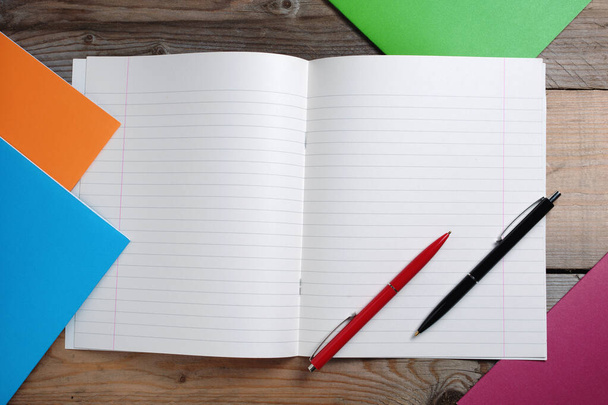 Colorful school notebooks and two ballpoint pens on wooden background, top view - Photo, Image