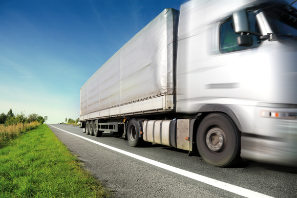 Zilveren vrachtwagen rijden op landweg - Foto, afbeelding