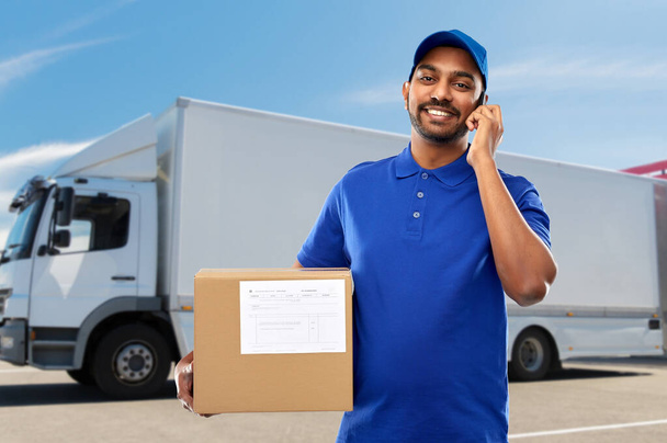 indian delivery man with smartphone and parcel box - Photo, Image