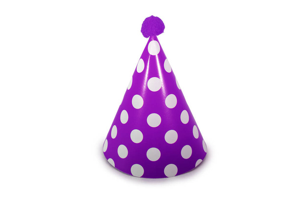 Un sombrero de cumpleaños púrpura con lunares blancos sobre un fondo blanco puro
 - Foto, Imagen
