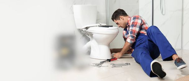 Professional plumber working with toilet bowl in bathroom, space for text. Banner design - Foto, Bild
