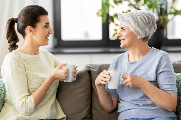 senior mother and adult daughter drinking coffee - Foto, Bild
