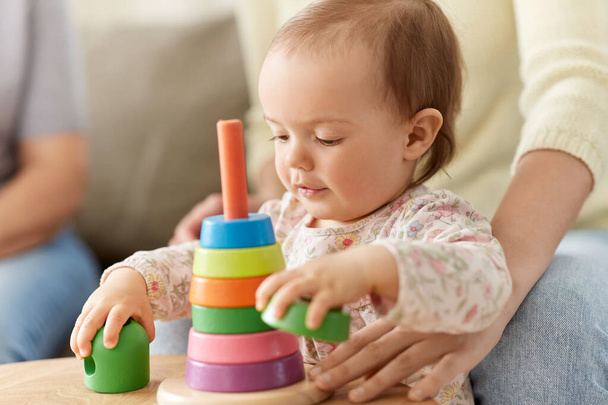 lovely baby girl playing with toy pyramid at home - Foto, Bild