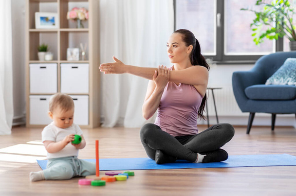 happy mother with little baby exercising at home - Valokuva, kuva