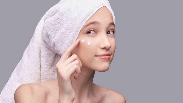 Young girl apply anti age cream. Skin care routine - Foto, afbeelding