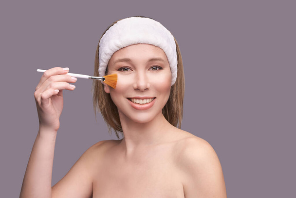 Girl with cosmetic brush. Beauty woman portrait. Pilling concept - Photo, Image