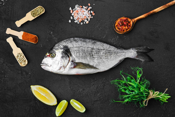 Dorada fish on the table with spice and herbs - Fotoğraf, Görsel