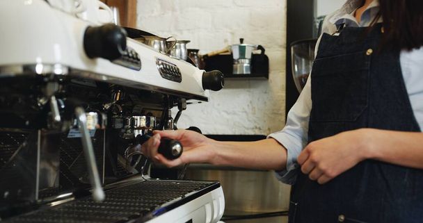 Portret pięknej młodej kelnerki parzącej kawę przy specjalnym ekspresie do kawy i uśmiechającej się do kamery. Zamknij się.. - Zdjęcie, obraz