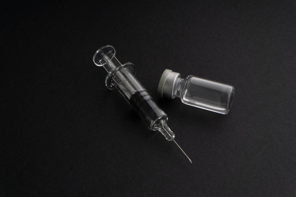 Closeup syringe and vials on black background. Healthcare dan Copy Space concept - Foto, immagini