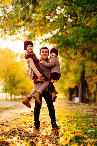 setting sun. dad with daughters walking and having fun in autumn Park. happy family. - Foto, Imagem