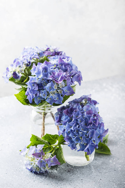 Greeting card concept. Amazing blue hydrangea flowers on the light table. Selective focus and close up image - Φωτογραφία, εικόνα