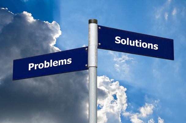 Πινακίδα δρόμου μπροστά από σκοτεινά σύννεφα που συμβολίζει την επιλογή μεταξύ "προβλημάτων" και "λύσεων" - Φωτογραφία, εικόνα