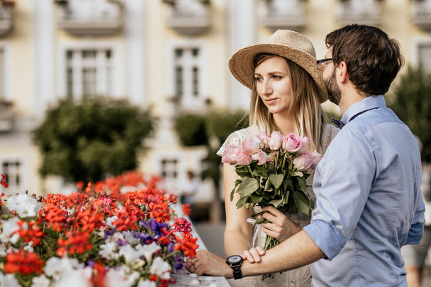 Close up of romantic couple in embrance with building on background - Photo, Image