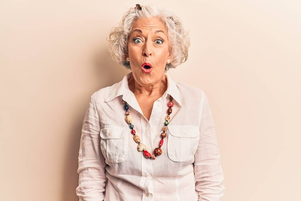 Senior mujer de pelo gris vistiendo ropa casual asustada y sorprendida con la boca abierta para sorpresa, cara de incredulidad  - Foto, Imagen