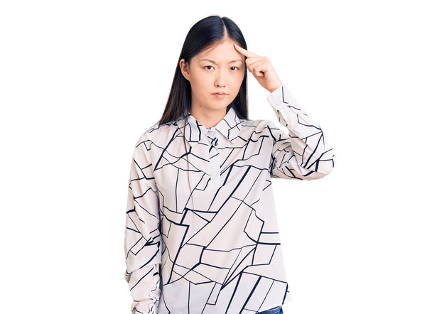 Nuori kaunis kiinalainen nainen yllään rento paita osoittaa tyytymätön näppylä otsaan, ruma infektio Mustapää. akne ja iho-ongelma  - Valokuva, kuva