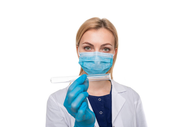 A girl doctor in a medical mask and gloves holding test tube on a white background - Photo, Image