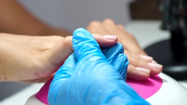 Proces manicure sprzętu. Piękne kobiece dłonie. Leczenie paznokci, proces robienia. Zastosowanie przezroczystego lakieru na bazie żelu   - Materiał filmowy, wideo