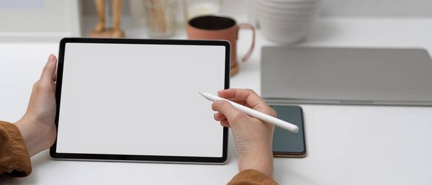 Ofisteki beyaz masanın üzerine stilus kalemle tablet kullanarak kadın görüntüsünü kapat  - Fotoğraf, Görsel
