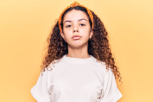 Beautiful kid girl with curly hair wearing casual clothes with serious expression on face. simple and natural looking at the camera.  - Фото, зображення