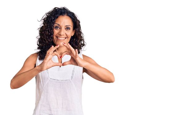 Middle age beautiful woman wearing casual sleeveless t shirt smiling in love showing heart symbol and shape with hands. romantic concept.  - Photo, Image