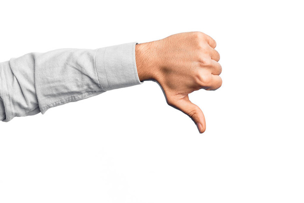 Mão de jovem caucasiano mostrando dedos sobre fundo branco isolado fazendo polegares para baixo gesto de rejeição, desaprovação antipatia e sinal negativo - Foto, Imagem