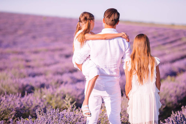 Rodina v levandulových květinách pole při západu slunce v bílých šatech a klobouku - Fotografie, Obrázek