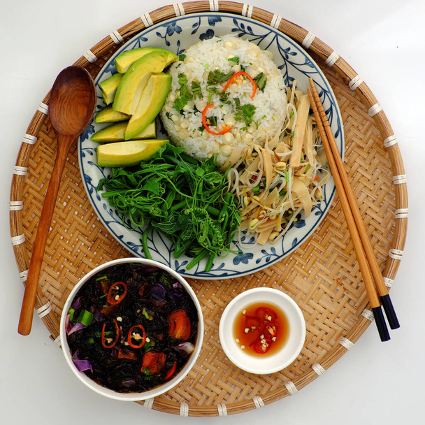 Vista superior comida familiar vietnamita para el almuerzo con comida vegetariana, verduras hervidas, aguacate con salsa, sopa de algas marinas, brote de bambú frito, plato vegano para la dieta, pero la nutrición
 - Foto, Imagen