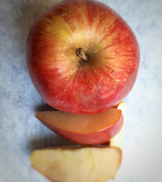 Yksi omena ja leikkaa sen kappaletta kauniisti valkoisella taustalla - Valokuva, kuva