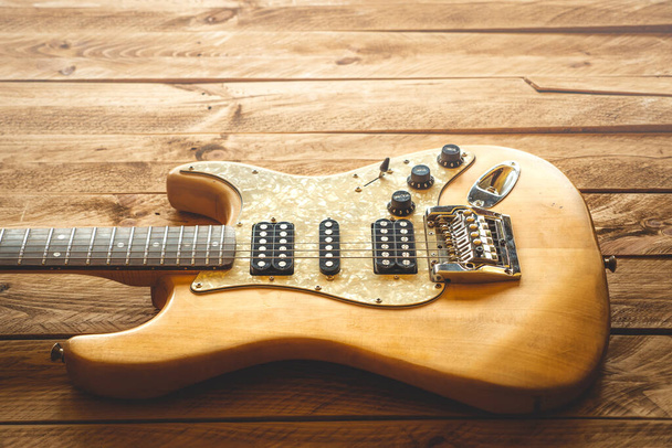 Beautiful vintage electric guitar on a brown wooden table, with copy space. - Photo, Image