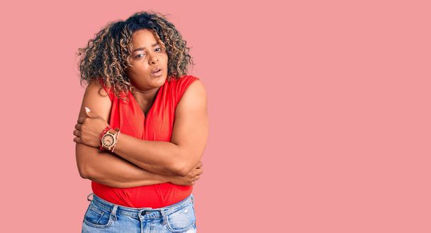 Young african american plus size woman wearing casual style with sleeveless shirt shaking and freezing for winter cold with sad and shock expression on face  - Photo, Image