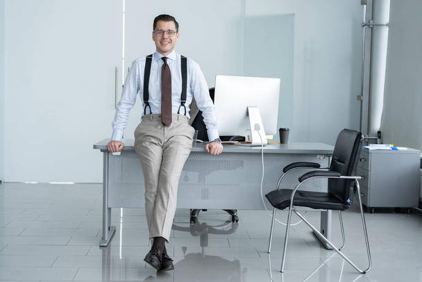 Portrait of a confident young businessman standing alone in a large modern office near his workplace. - Photo, image