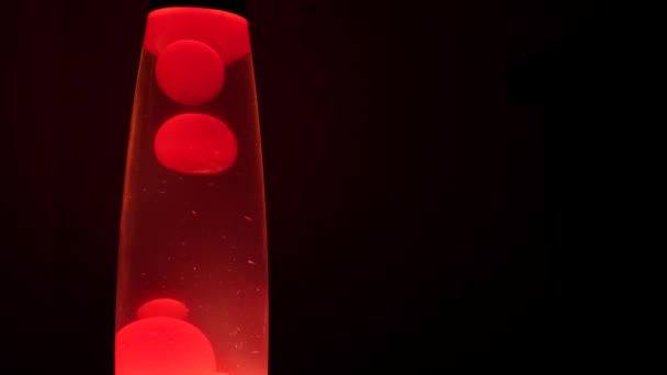 Kırmızı bir lav lambasının içinde hareket eden sıcak balmumundan oluşan eşsiz desenler. - Video, Çekim