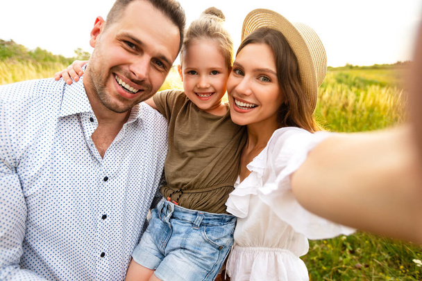 Happy loving family taking selfie on a picnic outdoor - Photo, Image