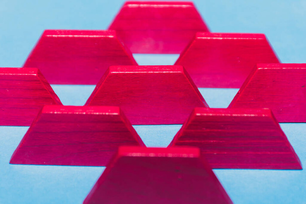Bright pink tangram geometric shapes lined up on bright blue background in a row. Child's toys and problem solving concepts. - Photo, Image