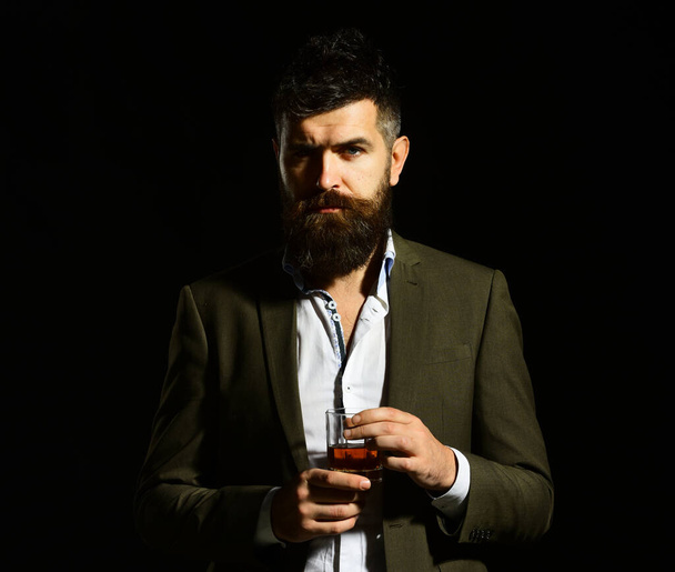 Businessman with beard and beverage on black background - Foto, imagen
