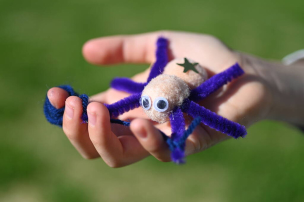 Bambino mano portare un ragno giocattolo fatto a mano nel cortile di casa. - Foto, immagini