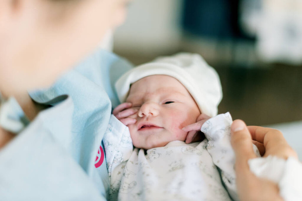 Egy újszülött első napja anya kezében egy kórházban. - Fotó, kép