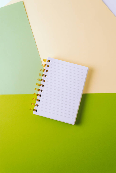 Nyílt notebook üres lap és arany spirál színes pasztell háttér. Az oktatás fogalma, az ötletek, tervek leírása. Helyet az sms-nek. Minimalizmus, lapos fektetés - Fotó, kép