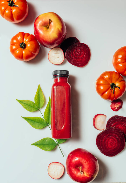 Red smoothie drink in bottle near ripe apples tomatoes and beets. Detox diet for healthy body and mind. health food concept. On light background - Photo, Image