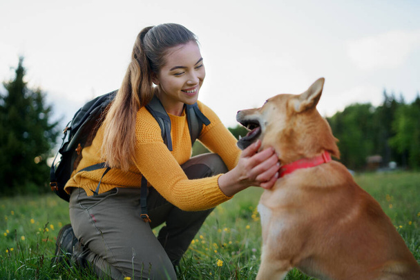 Young woman with a dog on a walk outdoors in summer nature. - Foto, Imagem