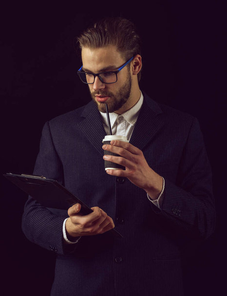 nachdenklicher Geschäftsmann im Anzug im Studio auf schwarzem Hintergrund - Foto, Bild