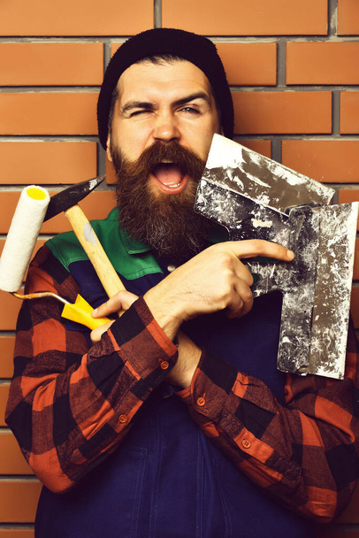 bearded builder man holding various building tools with happy face - Valokuva, kuva