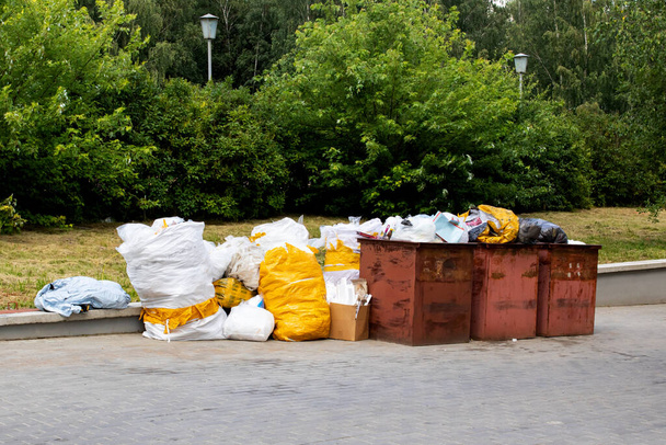 Мусорные баки и большие белые мешки для мусора на улице - Фото, изображение