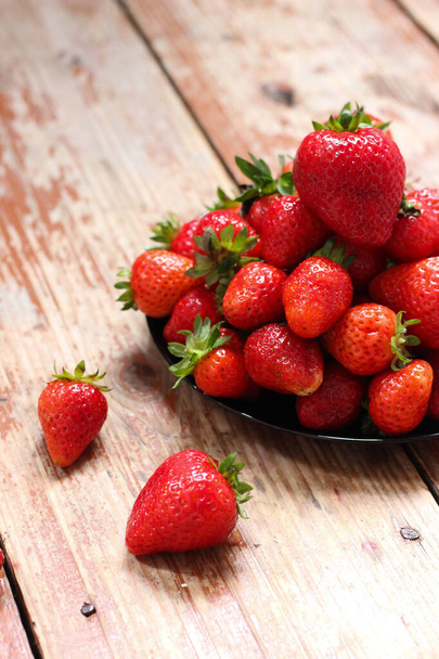 Juicy strawberries are lying on the wooden table. Summer vibes, top view - Фото, зображення